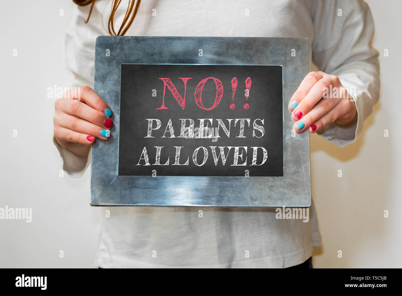 Enfant tenant un tableau noir avec le texte pas de parents admis Banque D'Images