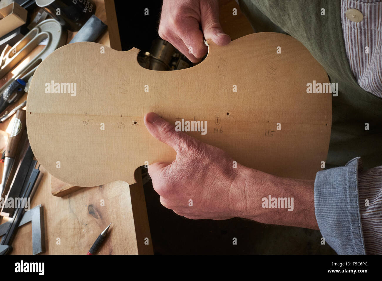Luthier à travailler à Londres, au Royaume-Uni, la sculpture l'arrière d'un violon Banque D'Images