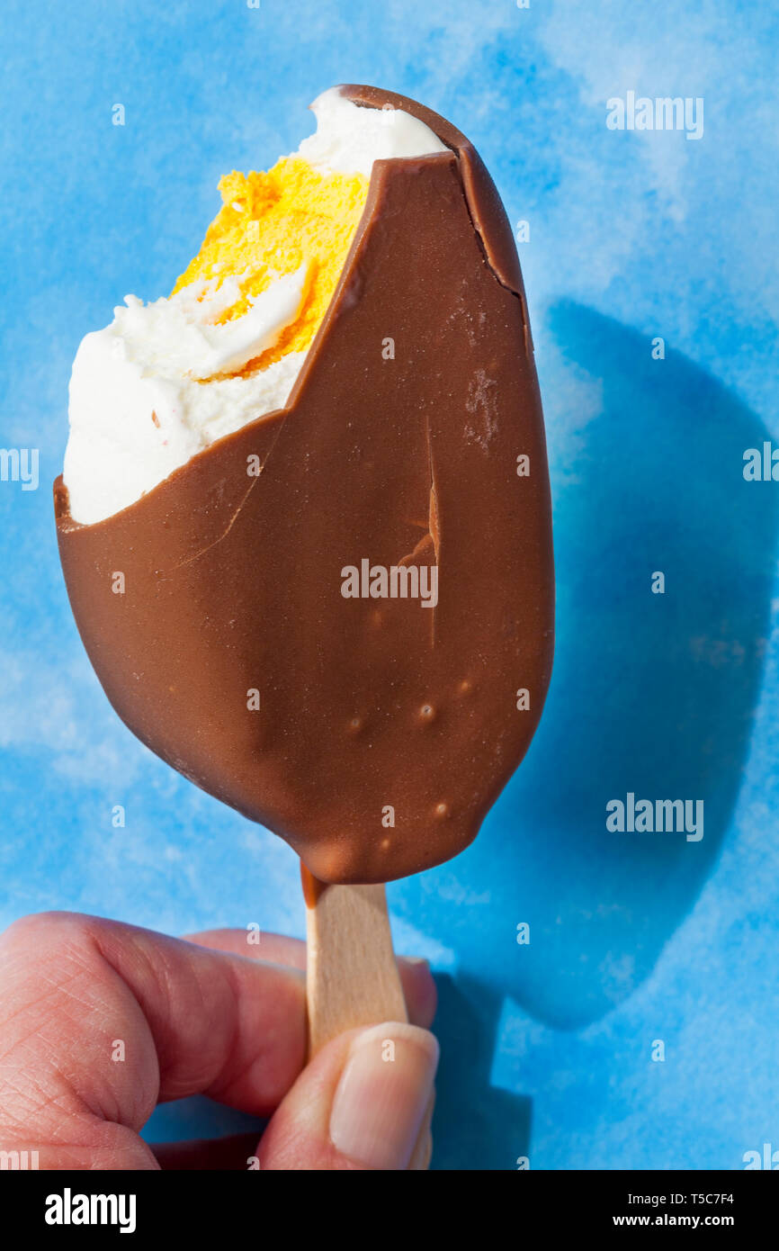 Manger des oeufs Cadbury crème glace à fond bleu - Notion de manger de la crème glacée aux beaux jours avec ciel bleu Banque D'Images