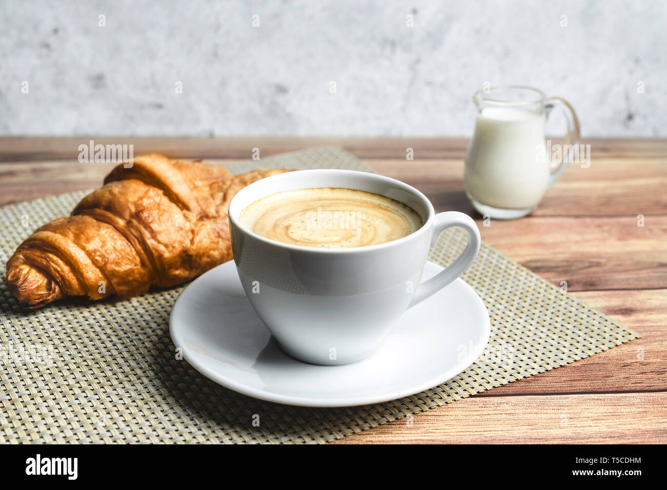 Le petit déjeuner parfait de croissant et café sur table en bois. Style rustique. Banque D'Images