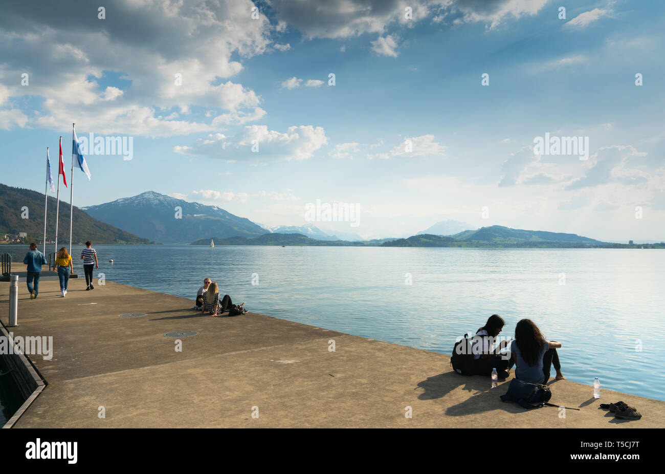 Zug, ZG / Suisse - 20 avril, 2019 : les adolescents se détendre et profiter d'une belle journée de printemps sur la rive du lac prés de la ville de Zug Banque D'Images