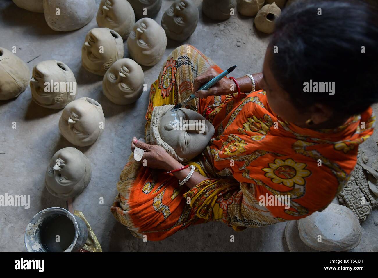 Un artisan, ajoute à la face de l'argile une idole de la déesse hindoue Durga avant la prochaine fête hindoue Durga Banque D'Images