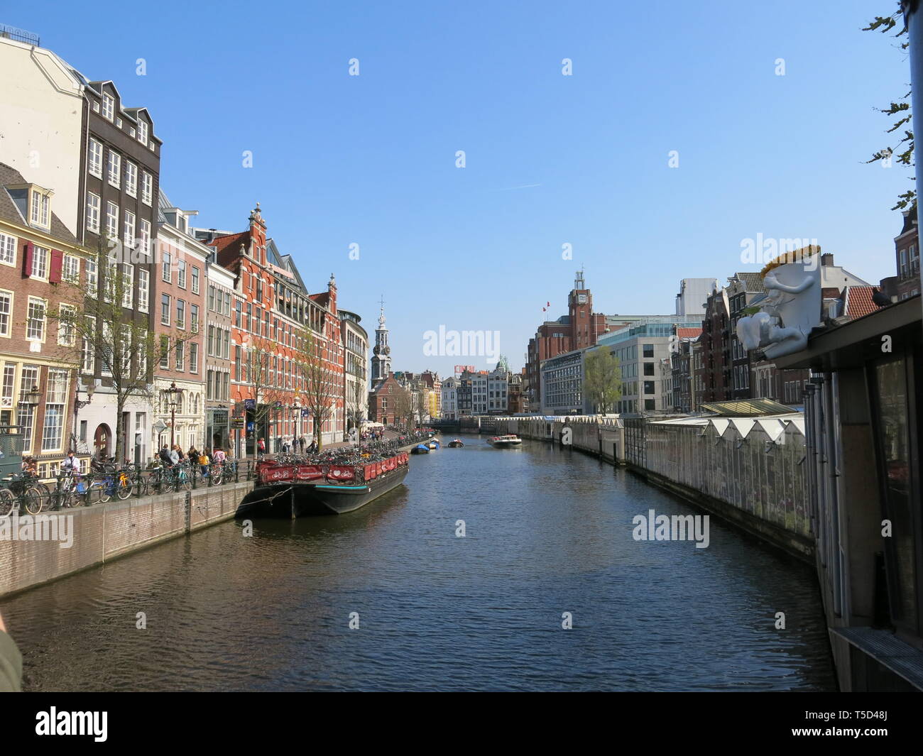 Vue sur le Canal Singel, avec marché aux fleurs d'Amsterdam, le Dam Square Experience Apartment, couverts en cale le long d'un côté du canal ; Avril 2019 Banque D'Images