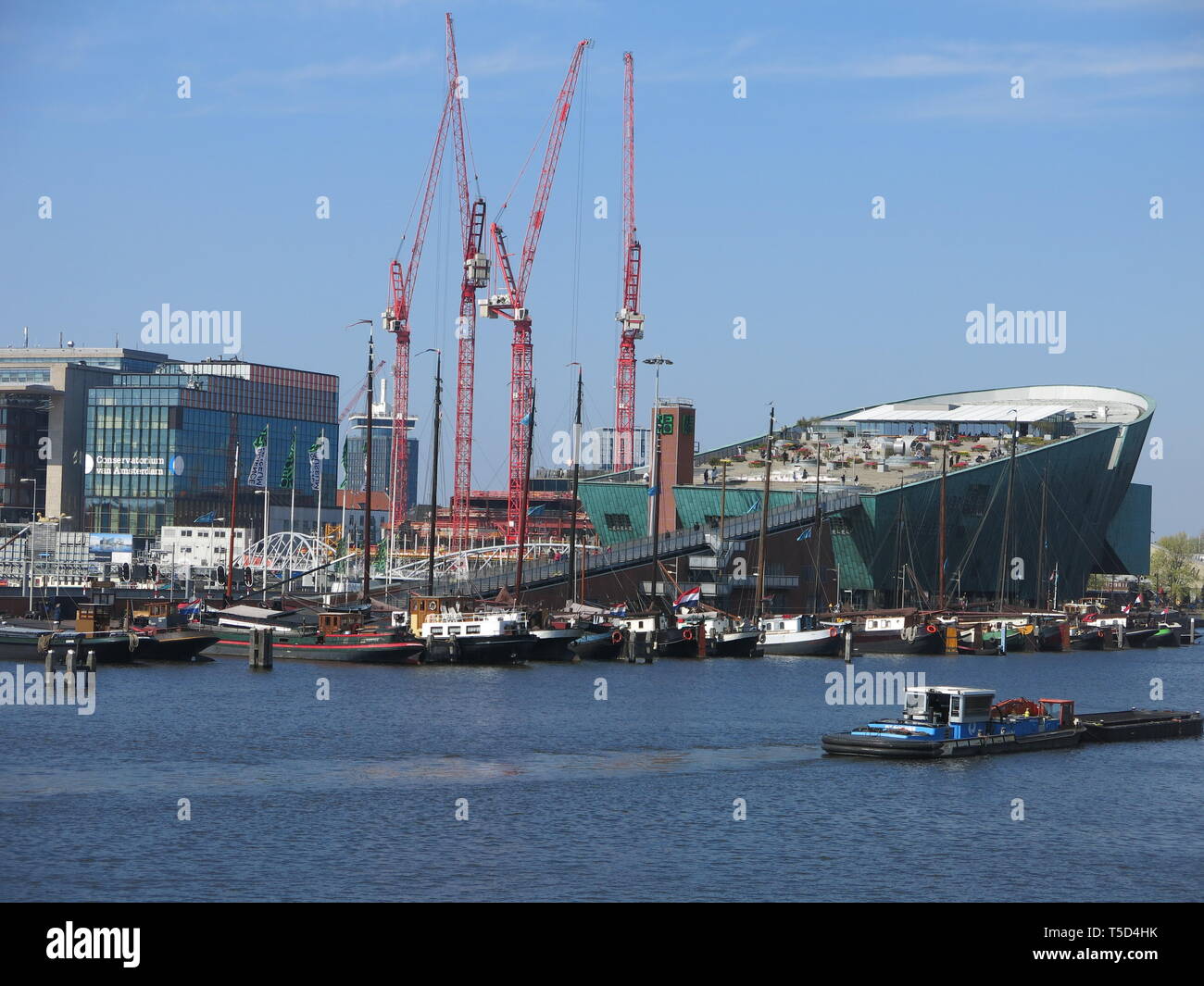Vue depuis l'autre côté du port, de l'impressionnant vert géant coque du bâtiment en forme de bateau pour Nemo Science & Technology Museum à Amsterdam Banque D'Images