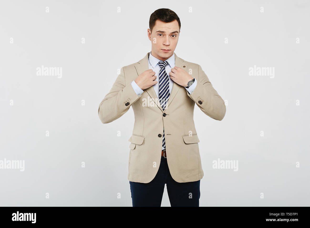 Homme d'affaires prospère dans la chemise blanche avec une cravate rayée,  dans un blazer beige et noir en jeans, isolée au fond blanc Photo Stock -  Alamy