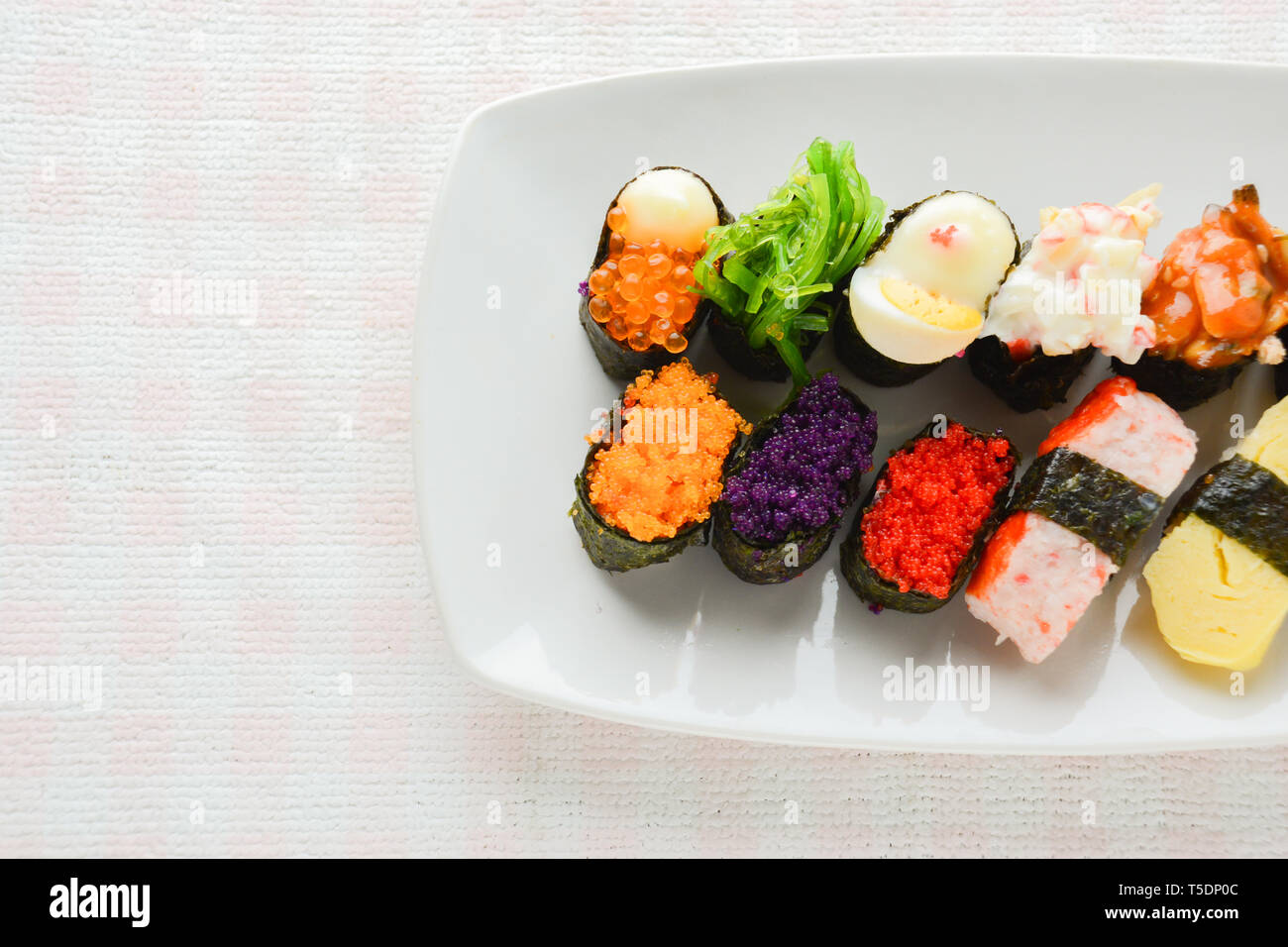 Sushi sur plaque blanche, thon, saumon, loup de mer, crevettes, oeufs sucrés sushi, cuisine japonaise Banque D'Images