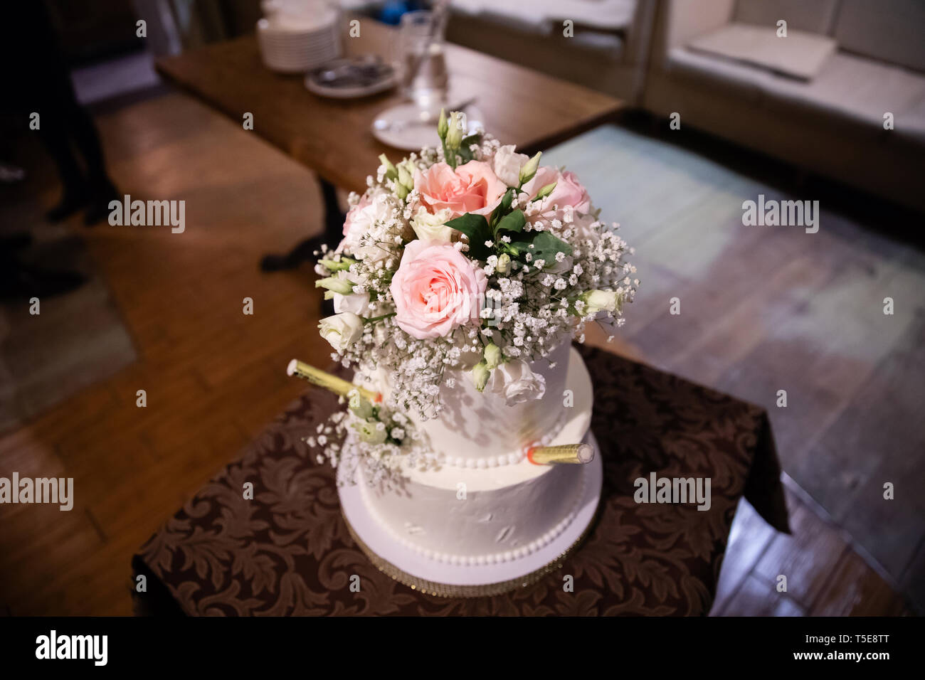 Gâteau de mariage décoré avec des fleurs sur la table dans un restaurant. Banque D'Images