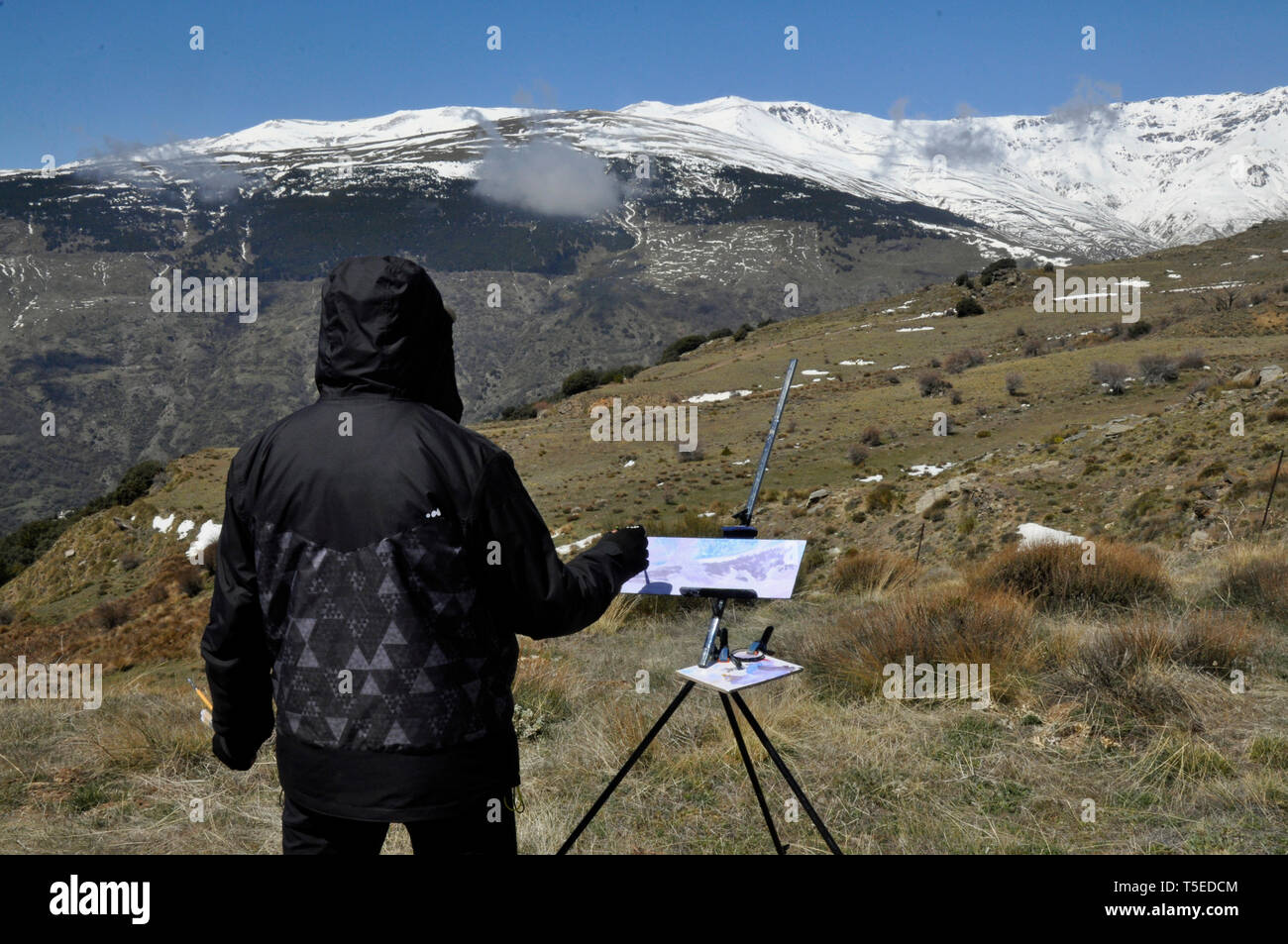 Un artiste en peinture d'un paysage d'hiver dans la pittoresque région de l'Alpujarra de la Sierra Nevada à Grenade, Andalousie, espagne. Banque D'Images