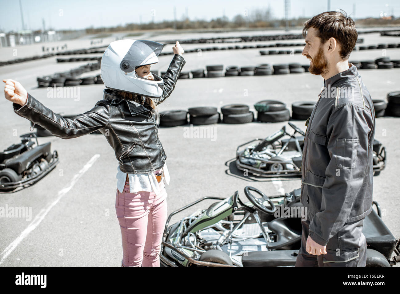 Happy female driver avec instructeur sur la piste de karting en plein air Banque D'Images