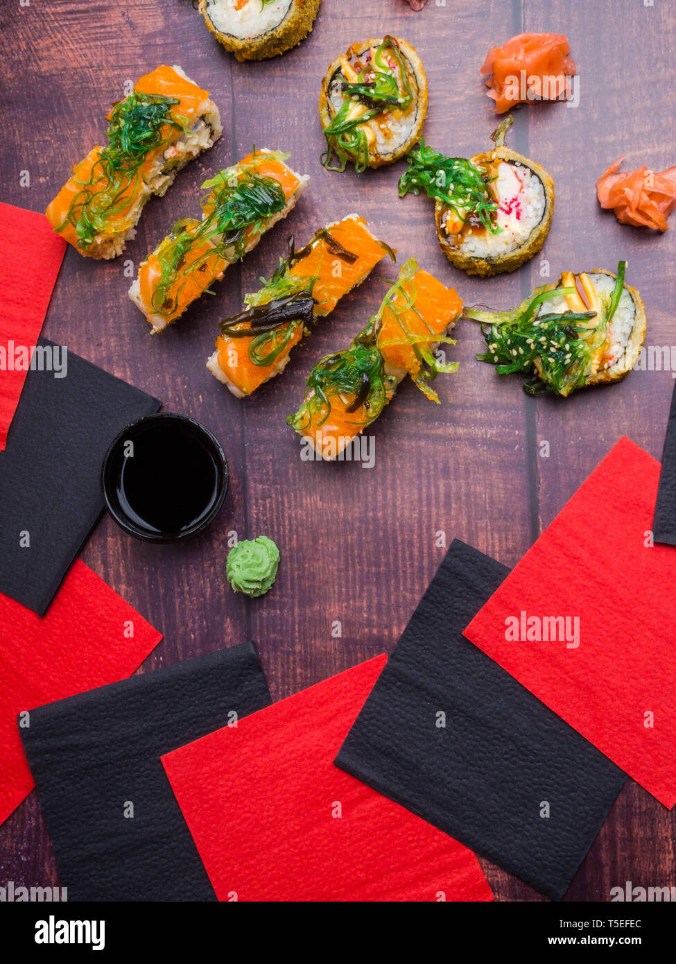 Tableau a servi avec sushi sur fond sombre. Rouleaux de sushi, wasabi, gingembre, wakame frais généraux, la cuisine japonaise traditionnelle Banque D'Images