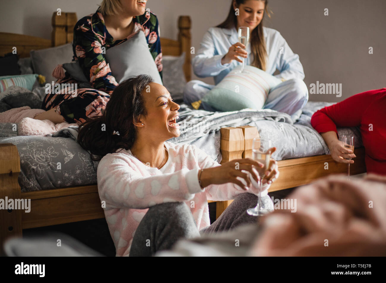 Petit groupe d'amies se détendre et parler tout en bénéficiant d'une soirée entre filles. Ils sont assis dans une chambre en pyjama. Banque D'Images