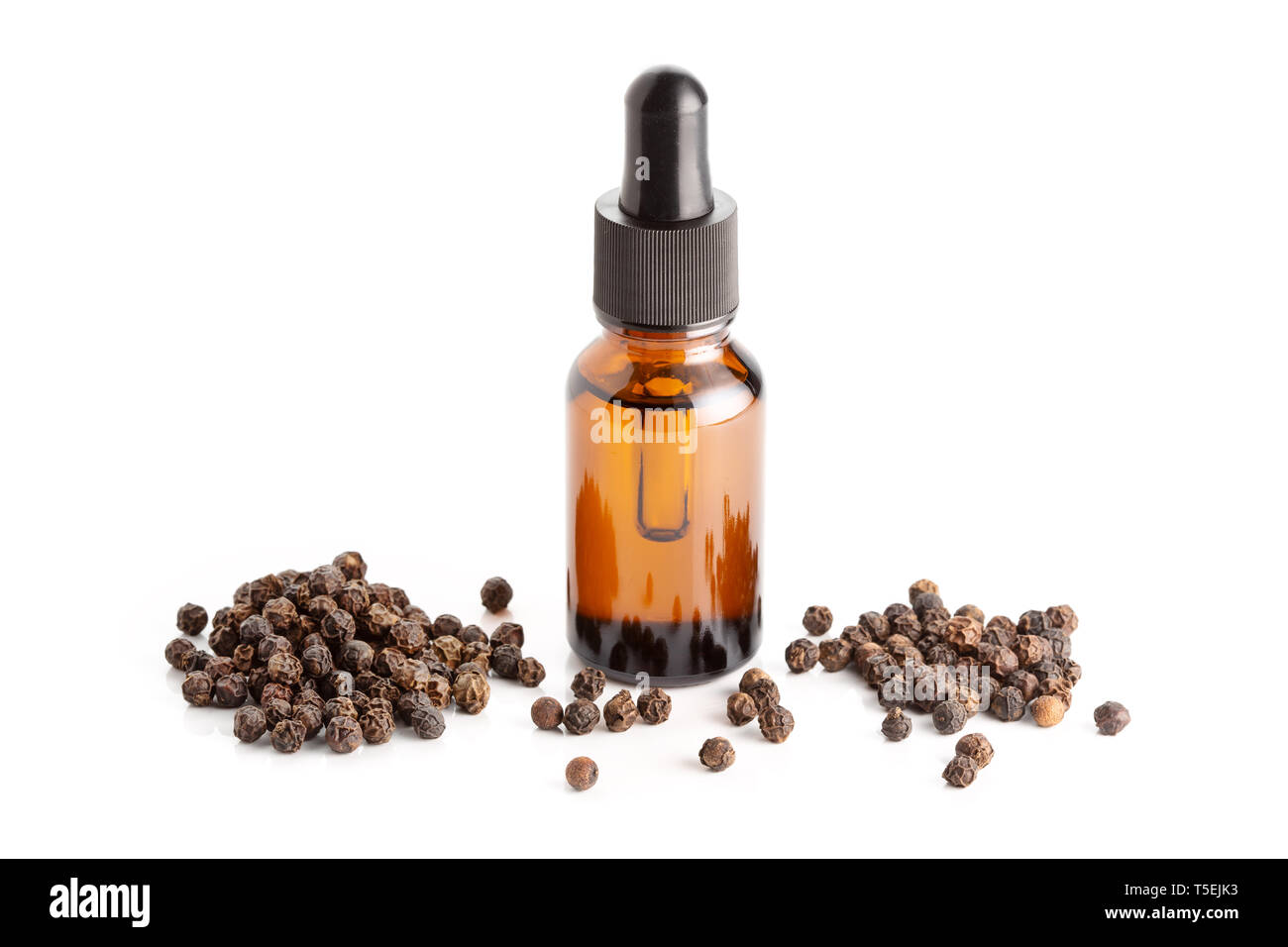 L'huile essentielle de poivre noir isolé sur fond blanc. Bouteille d'huile poivre noir avec compte-gouttes Banque D'Images