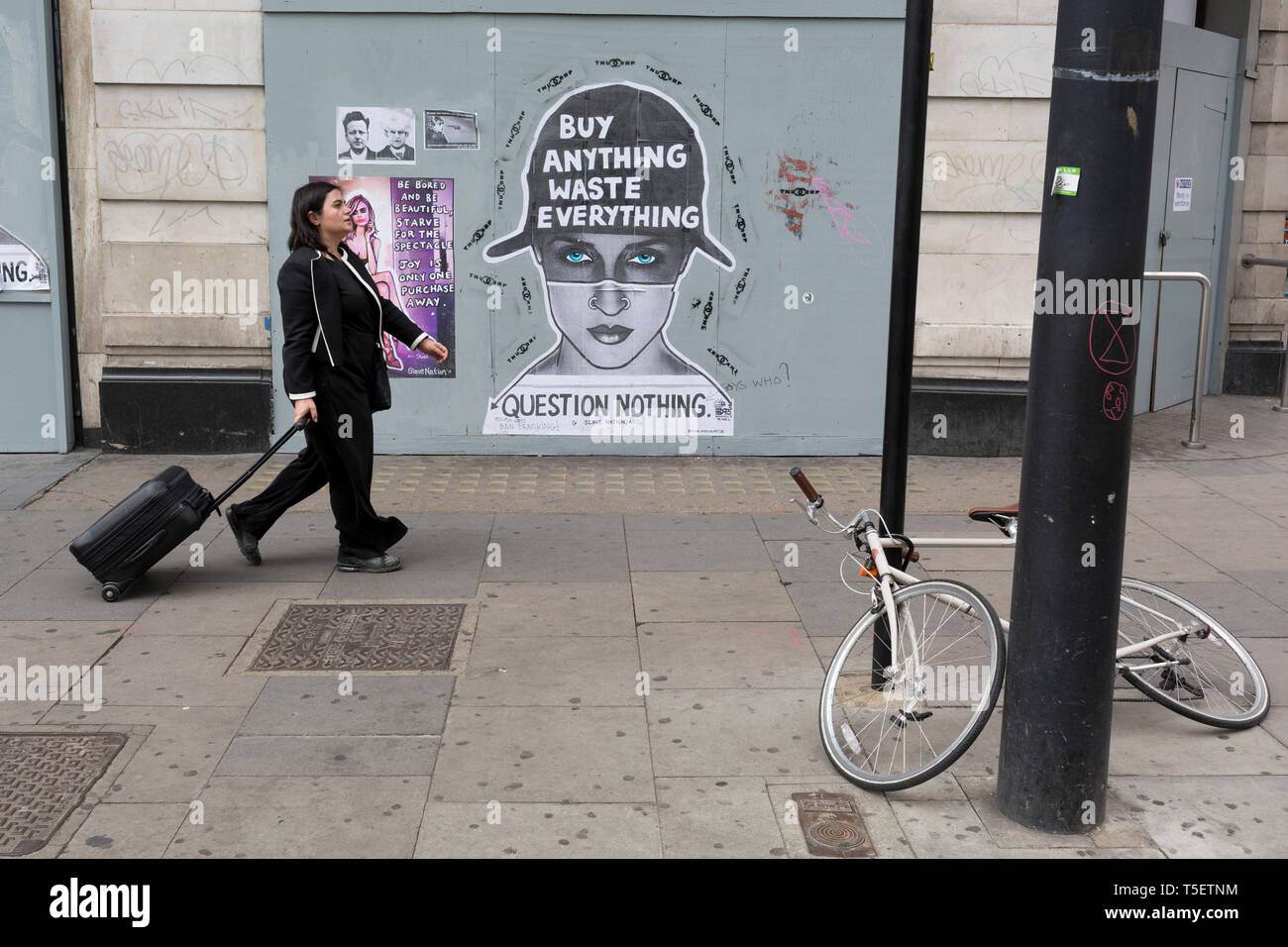 Sur la 10e journée consécutive de manifestations autour de Londres par la campagne sur le changement climatique l'extinction de la rébellion, les passants passent devant une affiche sur les déchets de consommation, le 24 avril 2019, à Marble Arch, Londres, en Angleterre. Banque D'Images