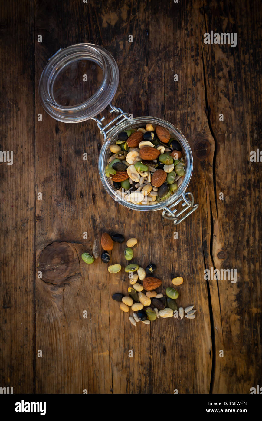 Bocal de haricots de soja rôties, les graines et les noix sur bois Banque D'Images