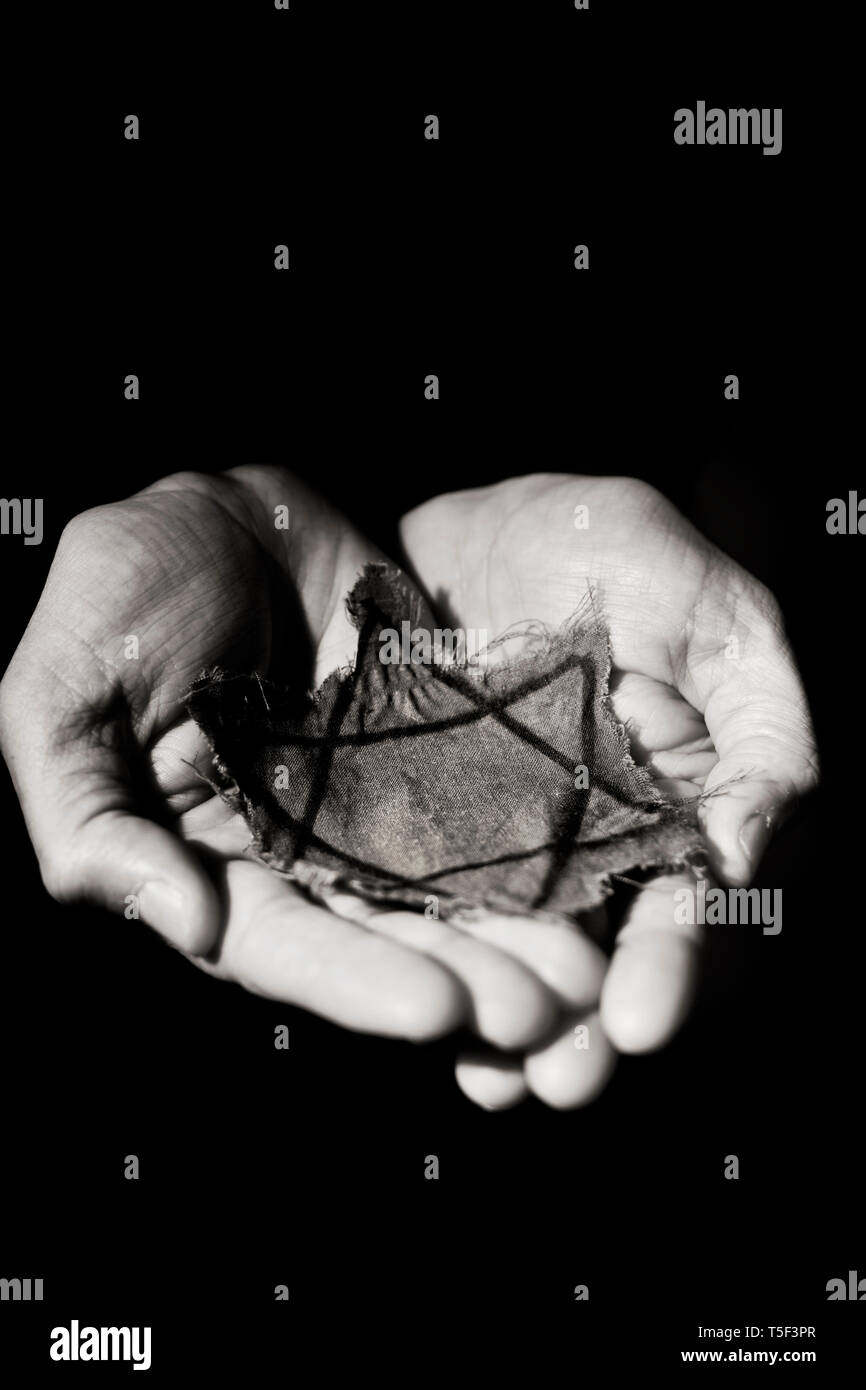 Libre d'un insigne juif déchiqueté entre les mains d'un homme Banque D'Images