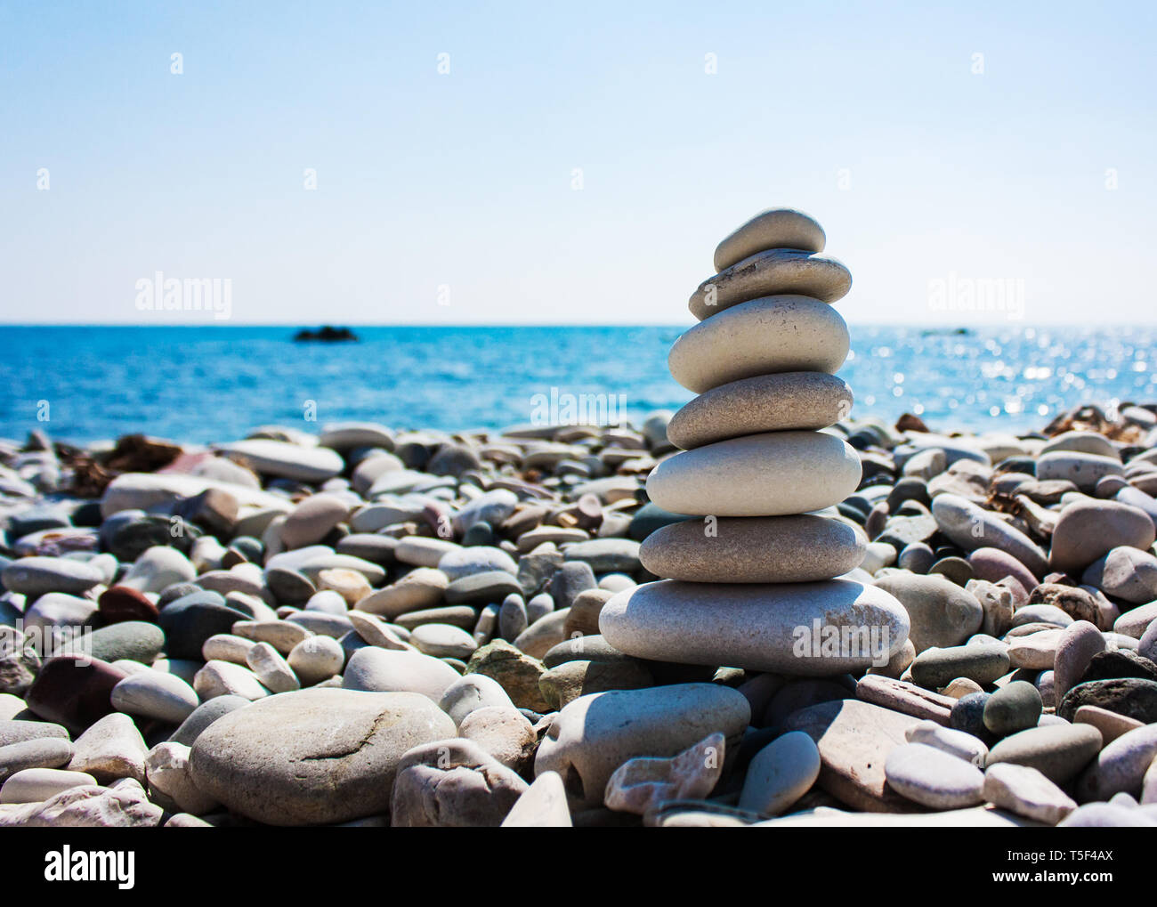 Balance des pierres sur la main sur le fond de la mer. Le concept de la paix de l'esprit, l'harmonie, la spiritualité Banque D'Images