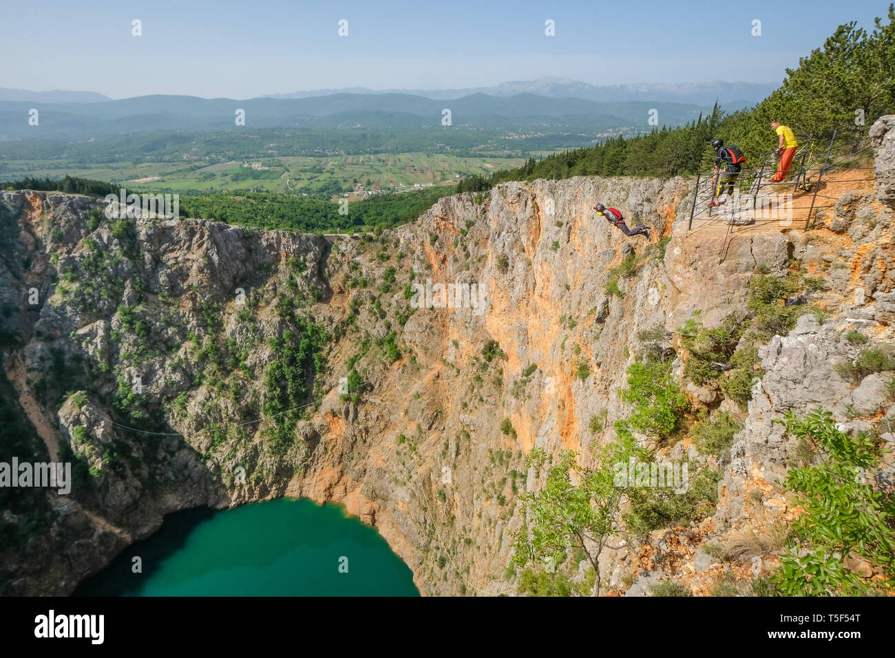 IMOTSKI, CROATIE - Mai 02 : un homme avec un parachute et avec ses amis sautant au-dessus du lac rouge, Split-dalmatie, Imotski, la Croatie le 02 mai 2018 à Imotski, Croatie. Banque D'Images