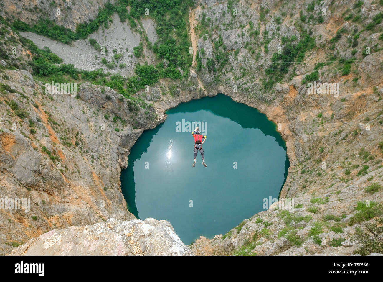 IMOTSKI, CROATIE - Mai 03 : un homme avec un saut en parachute au-dessus du lac rouge, Split-dalmatie, Imotski, la Croatie le 03 mai, 2018 à Imotski, Croatie. Banque D'Images