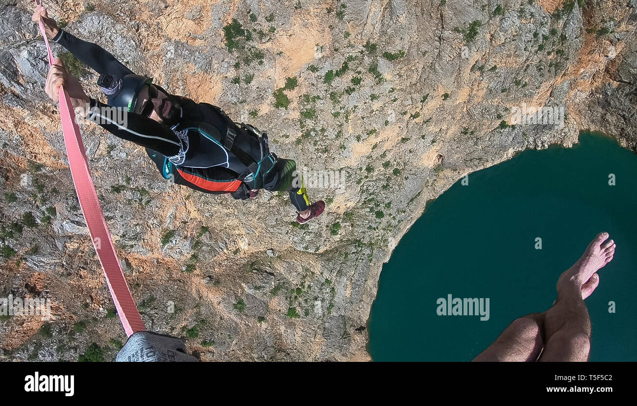 IMOTSKI, Croatie - 02 MAI : deux personnes accrochés sur une corde tendue au-dessus du lac rouge, Split-dalmatie, Imotski, la Croatie le 02 mai 2018 à Imotski, Croatie. Banque D'Images