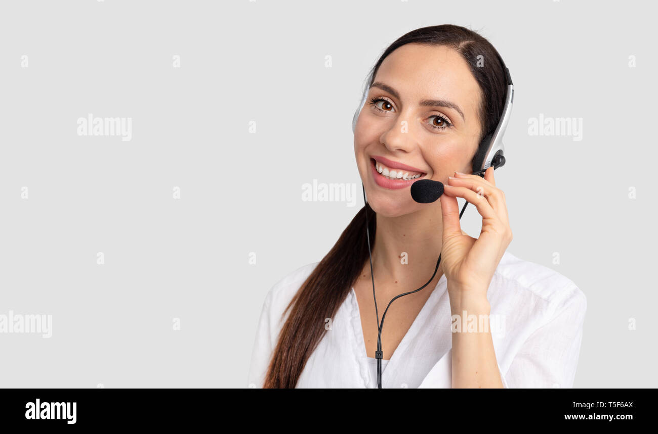 Consultant du centre d'appel dans le casque sur fond gris. L'opérateur d'assistance avec casque Banque D'Images