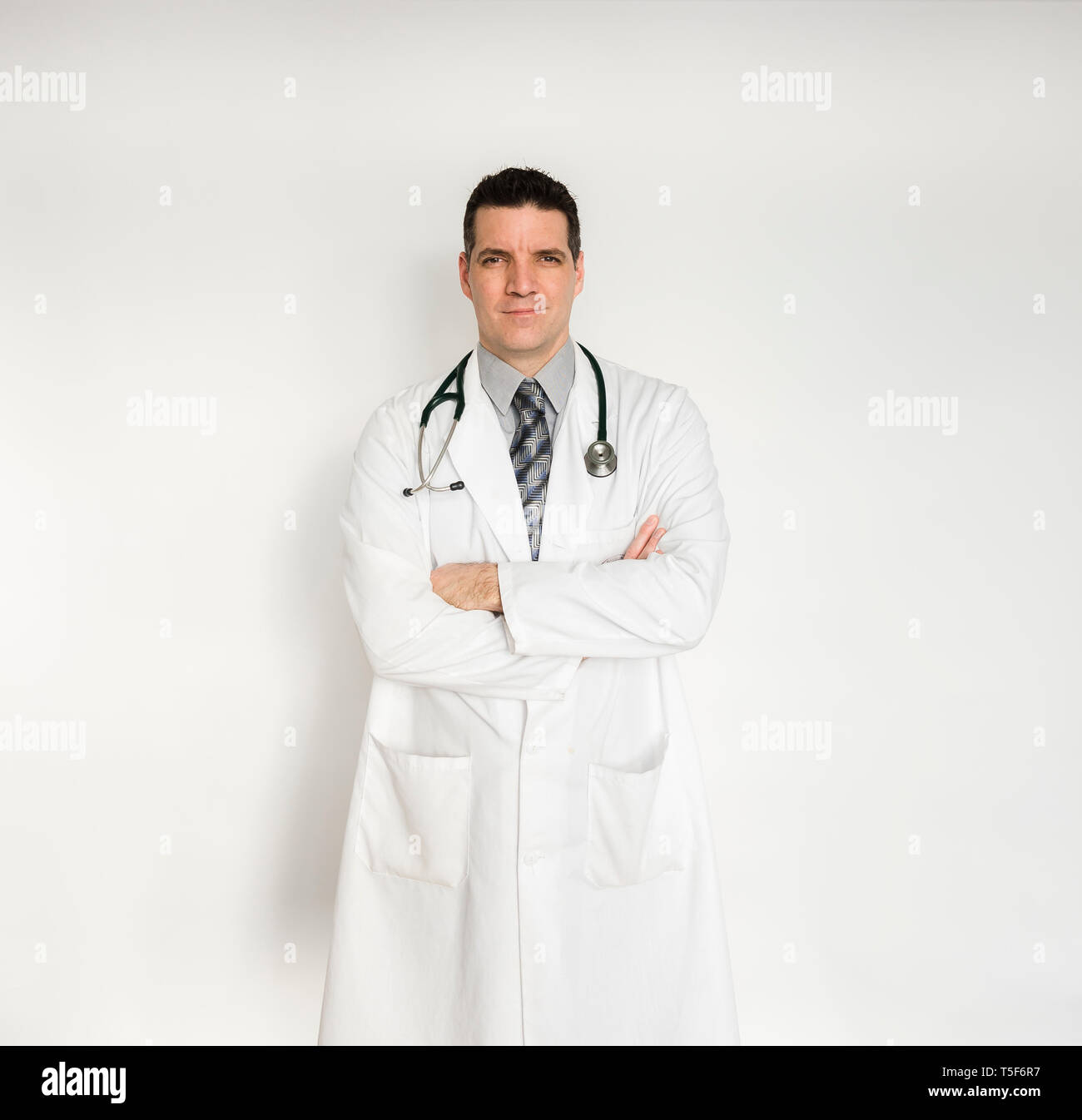 Médecin en blouse blanche debout, les bras croisés. Banque D'Images