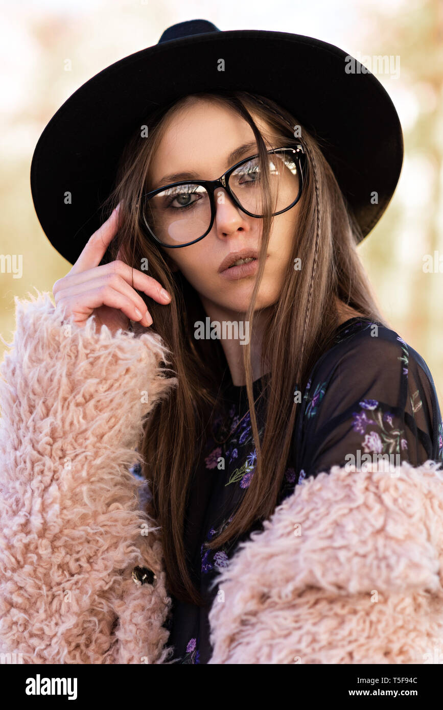 Belle brune dans la mode des lunettes et un pelage hirsute. Banque D'Images