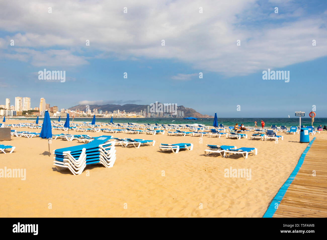 Signer et empilé des chaises longues chambres sur plage vide à Benidorm espagne Banque D'Images