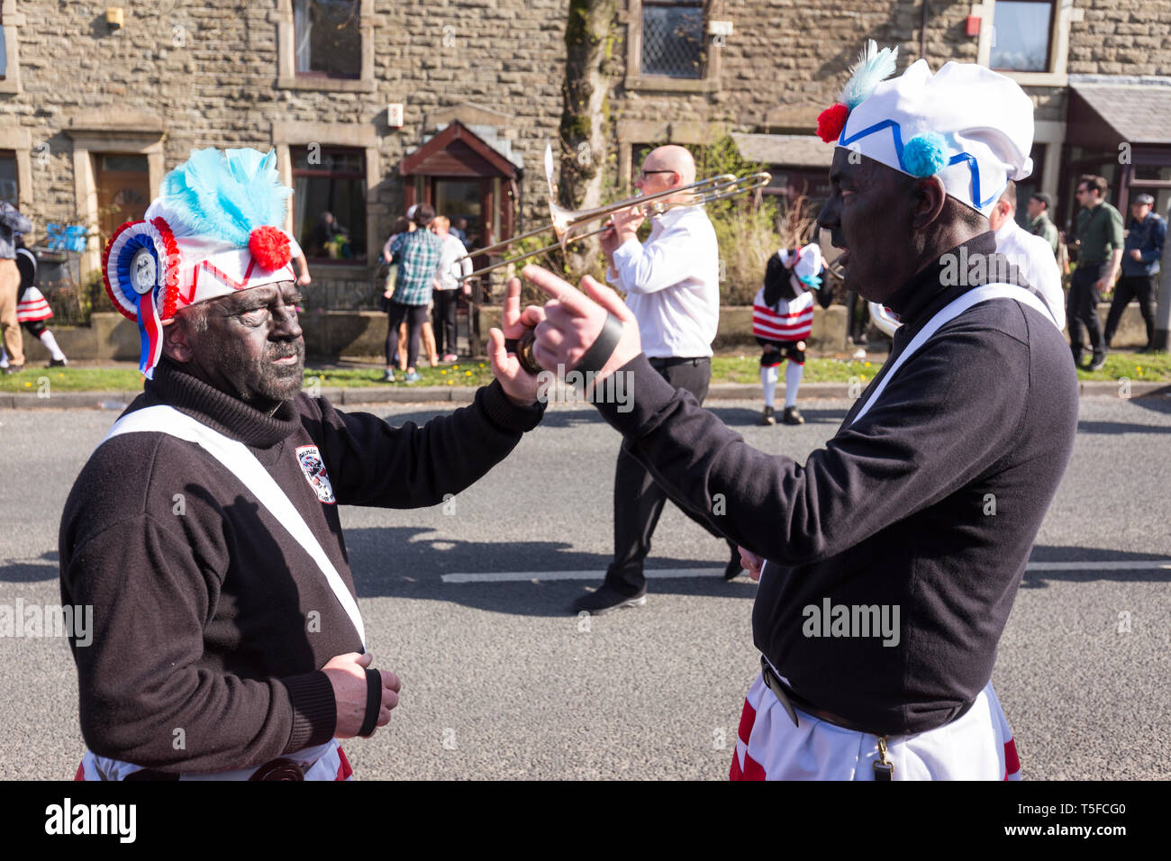 © Chris Bull. 20/4/19 Bacup , Lancashire, Angleterre. Le Coconutters Morrismen du Britannia limite de frontière dans la danse Bacup , Lancashire (aujourd'hui samedi 20 avril 2019). Dans une tradition remontant à des centaines d'années, chaque samedi de Pâques l'morrismen ont exécuté des danses païennes pour accueillir le printemps et éloigner les mauvais esprits de l'hiver. Le nom Coconutters vient à partir du moment où les mineurs de charbon devrait porter les coquilles de noix de coco sur les genoux pour la protection dans les fosses. Ils noircissent leurs visages pour les dissimuler des mauvais esprits et à tenir compte de l'exploitation du charbon les traditions de la région. Banque D'Images