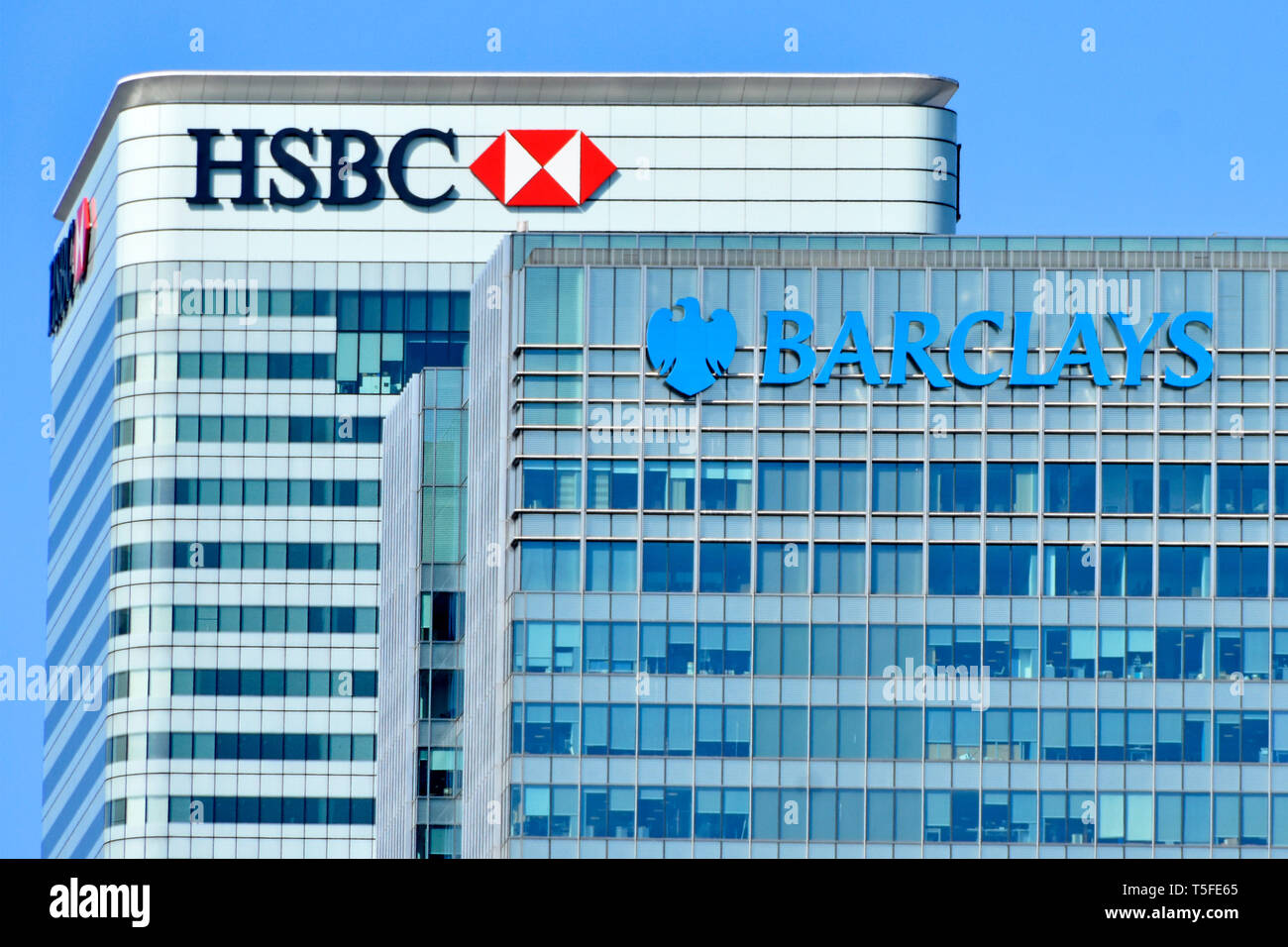 Close up sur le toit du QG de la HSBC et Barclays corporate banking business logo ci-dessus et façade fenêtre bardage répétitives Canary Wharf London Docklands UK Banque D'Images