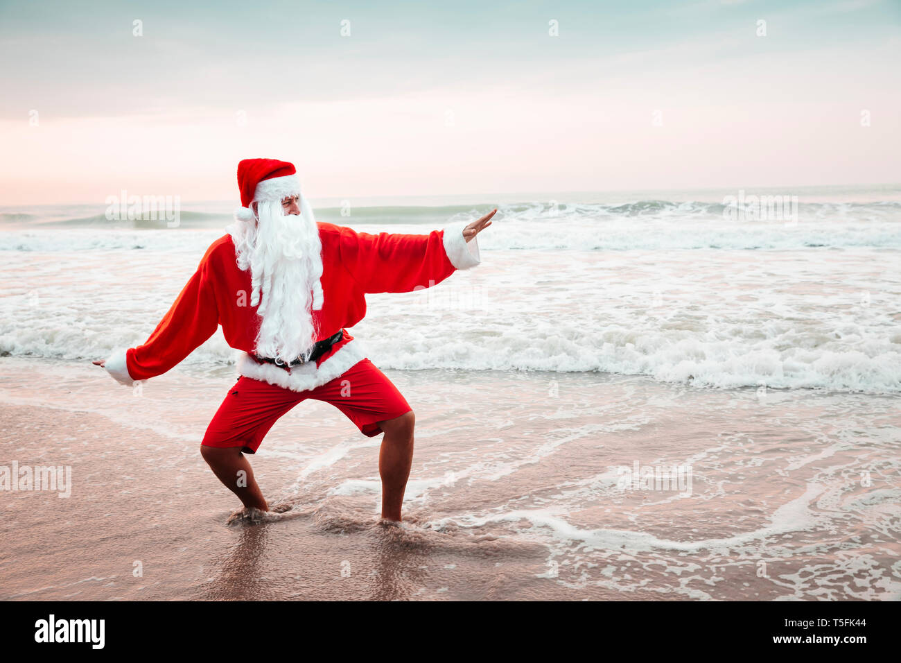 La Thaïlande, l'homme déguisé en Père Noël, posant sur la plage au coucher du soleil Banque D'Images