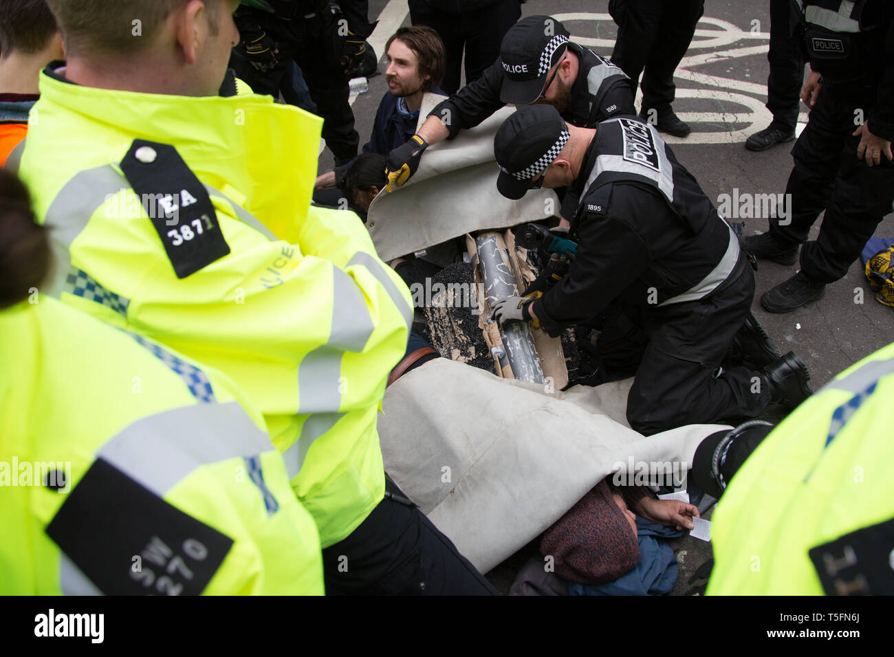 London UK 24 avril 2019 agents de police couper à travers un tube reliant deux manifestants à Marble Arch au cours de protester par les écologistes. Banque D'Images