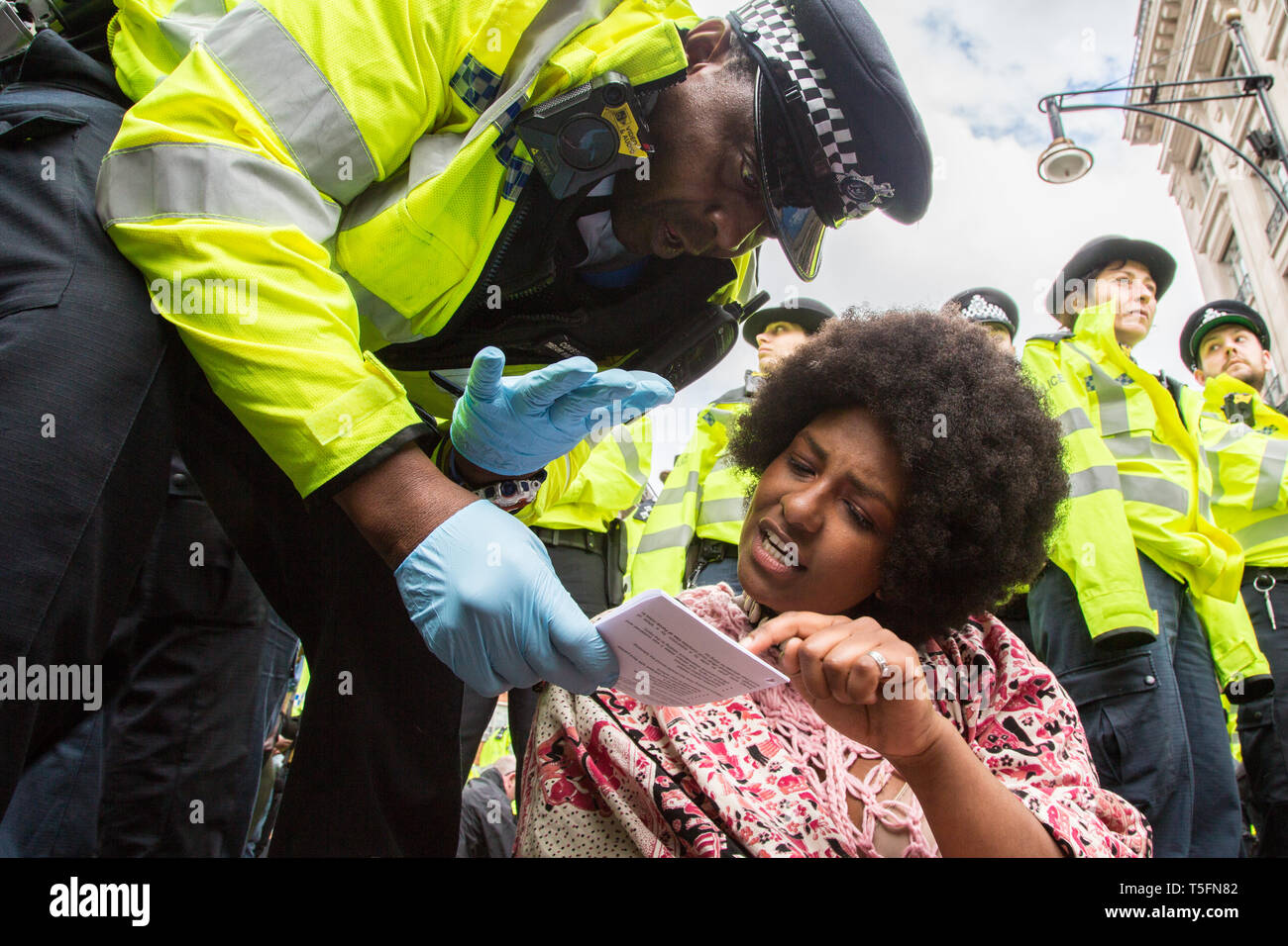 London UK 24 avril 2019 Un écologiste lit une copie de l'article 14 de la loi relative à l'ordre de la police que la police se déplacer pour effacer des manifestants à Marble Arch. Banque D'Images