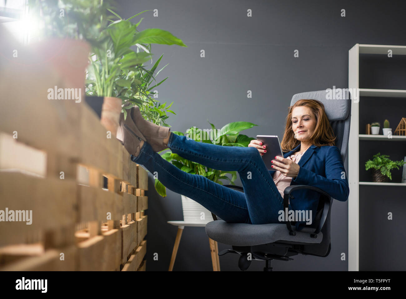 Mature businesswoman working in office durable, using digital tablet Banque D'Images