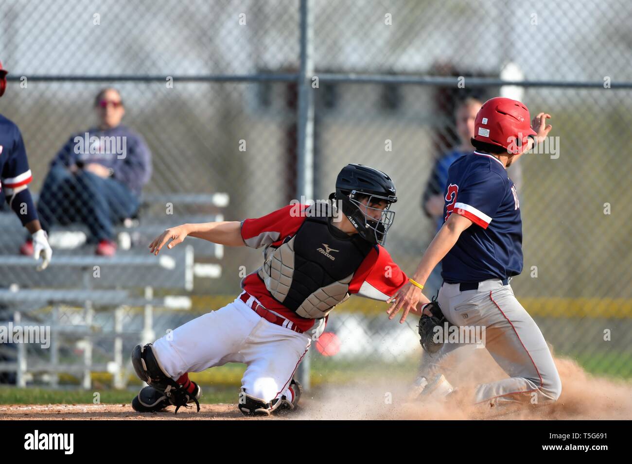 Base Runner glisser en toute sécurité dans le marbre pour marquer un point d'avance sur l'opposant à catcher tag. USA. Banque D'Images