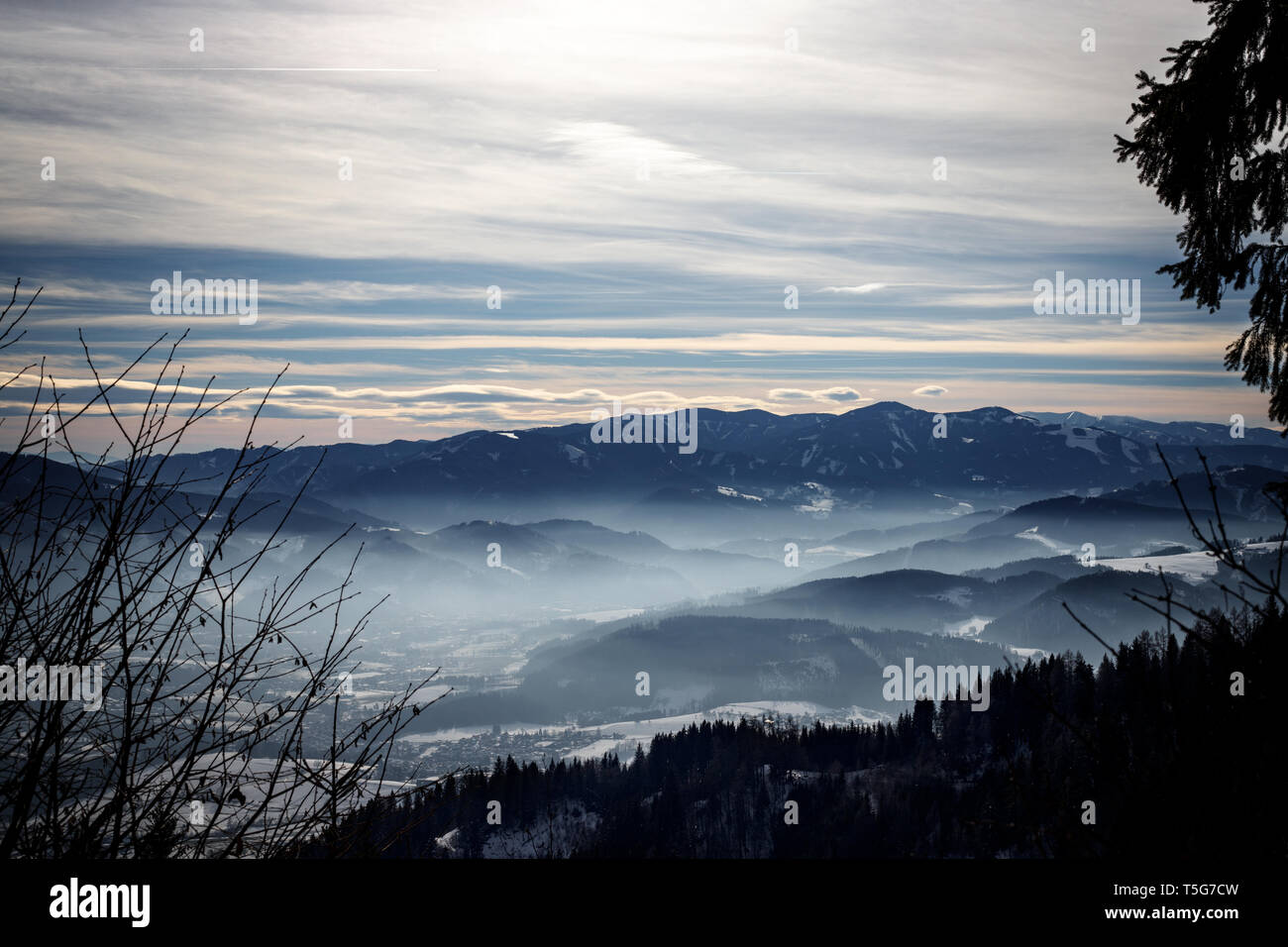 Avec un panorama d'hiver Alpin misty valley et les montagnes brumeuses du ciel d'hiver dans les Alpes européennes Banque D'Images