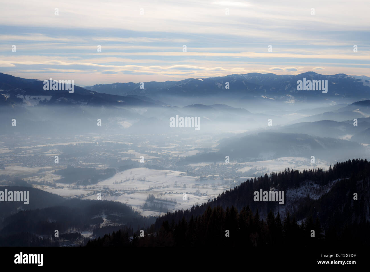 Avec un panorama d'hiver Alpin misty valley et les montagnes brumeuses du ciel d'hiver dans les Alpes européennes Banque D'Images