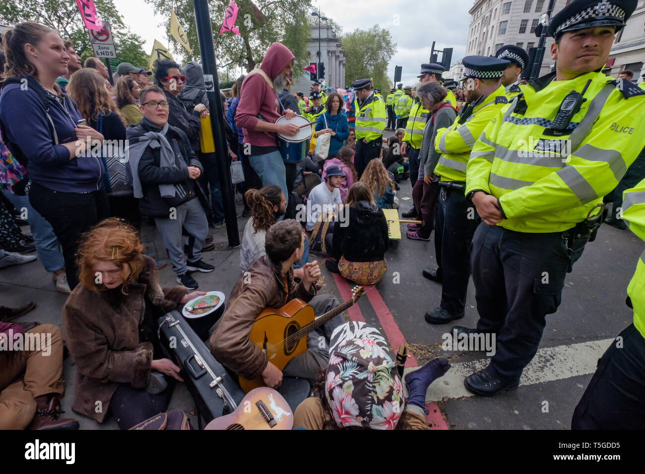 Londres, Royaume-Uni. 24 avril 2019. La police a été suppression de personnes bloquant la rue Oxford, le dernier bloc de la route autour de Marble Arch cet après-midi. Certaines personnes ont été verrouillé sur et être soigneusement découpée par des officiers, tandis que d'autres assis tranquillement entouré par la police et a attendu d'être arrêté alors qu'une petite foule vu par plusieurs lignes d'agents de police a tenté de les amener à s'éloigner. Du Marble Arch la protestation a continué avec des tambours et de la danse, de la nourriture et des centaines de tentes. Peter Marshall/Alamy Live News Banque D'Images