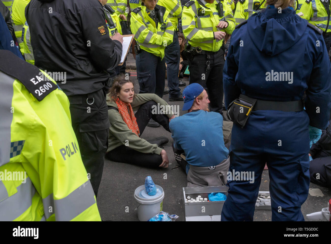 Londres, Royaume-Uni. 24 avril 2019. La police a été suppression de personnes bloquant la rue Oxford, le dernier bloc de la route autour de Marble Arch cet après-midi. Certaines personnes ont été verrouillé sur et être soigneusement découpée par des officiers, tandis que d'autres assis tranquillement entouré par la police et a attendu d'être arrêté alors qu'une petite foule vu par plusieurs lignes d'agents de police a tenté de les amener à s'éloigner. Du Marble Arch la protestation a continué avec des tambours et de la danse, de la nourriture et des centaines de tentes. Peter Marshall/Alamy Live News Banque D'Images