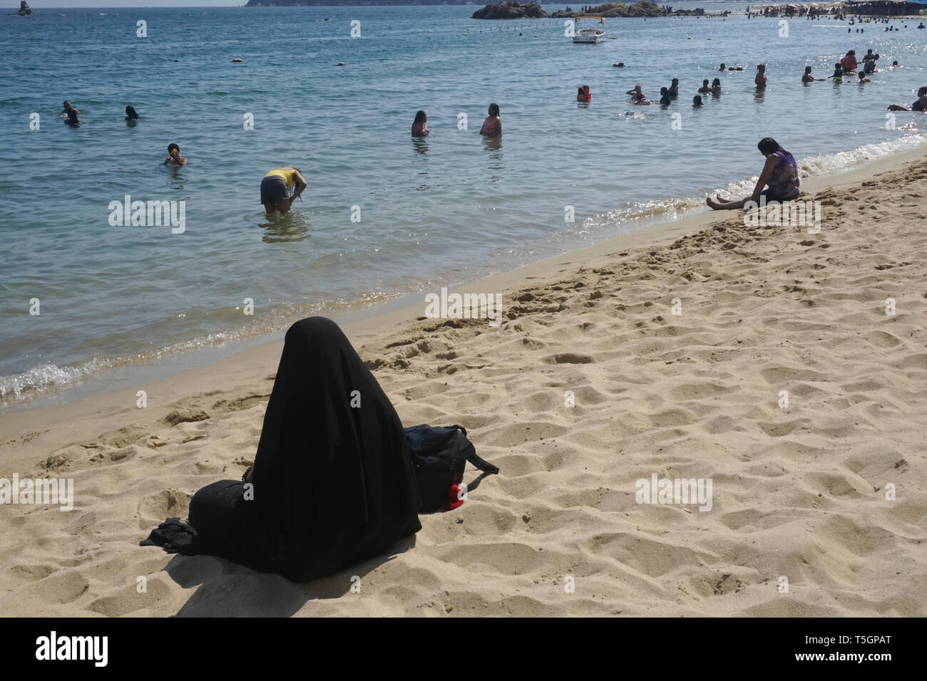 Woman in hot vêtements religieux à la plage au Mexique Banque D'Images