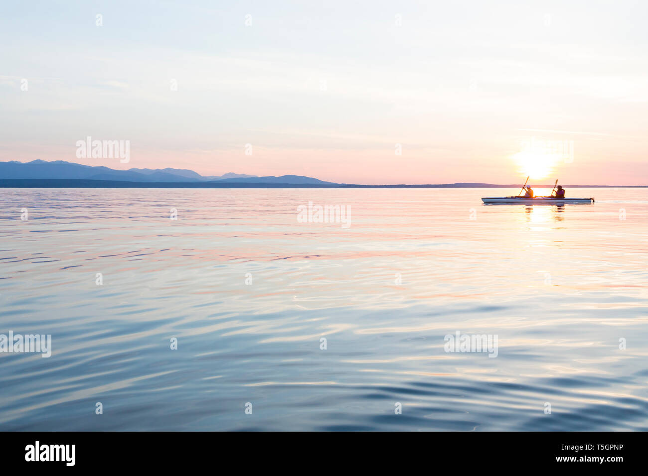 Les femmes personnes kayak de mer Bateau canotage en eau calme au coucher du soleil. L'aventure de plein air active sports d'eau. Voyage, la destination, l'équipe repose. Banque D'Images