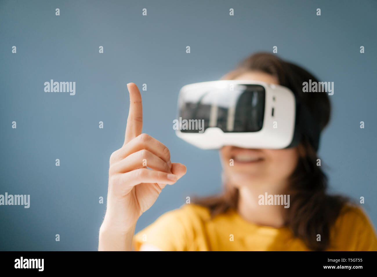 Femme portant des lunettes VR, regarder doigt soulevé Banque D'Images