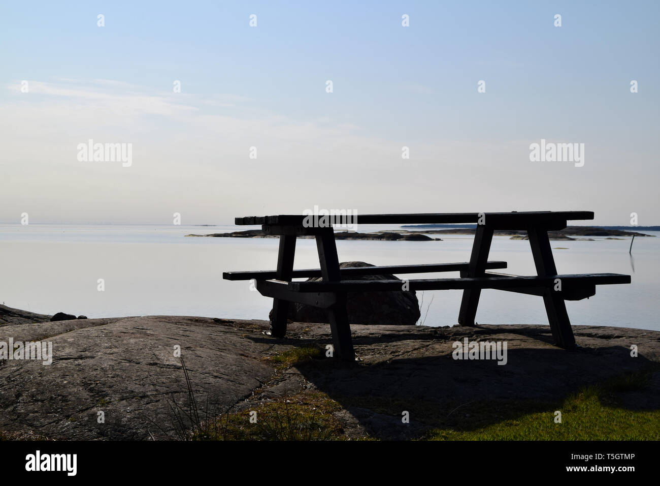 Table de pique-nique vide avec de l'eau tranquille dans l'arrière-plan Banque D'Images