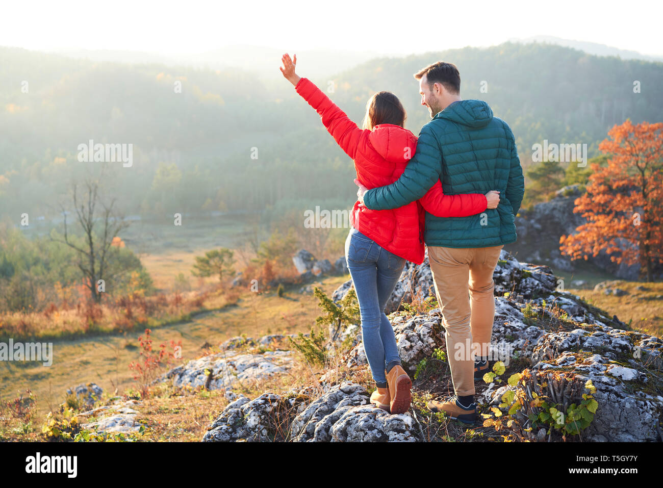 Vue arrière de l'heureux couple en randonnée dans les montagnes debout sur rock Banque D'Images