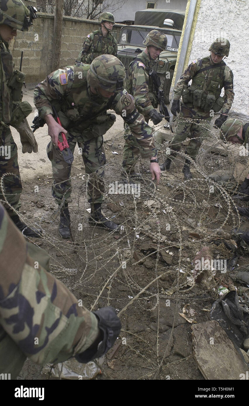 Le 18 février 2002 - Gjilane, Kosovo, Yougoslavie - les fantassins de la Compagnie Bravo, 2e Bataillon, 14e Régiment d'infanterie, d'éliminer les barbelés d'un lot à la fin de l'Allée des Roms du Kosovo, à Gjilane, le 18 février 2002. ..Le fantassin terminé la première étape d'un projet en trois parties visant à nettoyer la corbeille-couverts dans une aire de jeux. (Crédit Image : © Bill Putnam/Zuma sur le fil) Banque D'Images