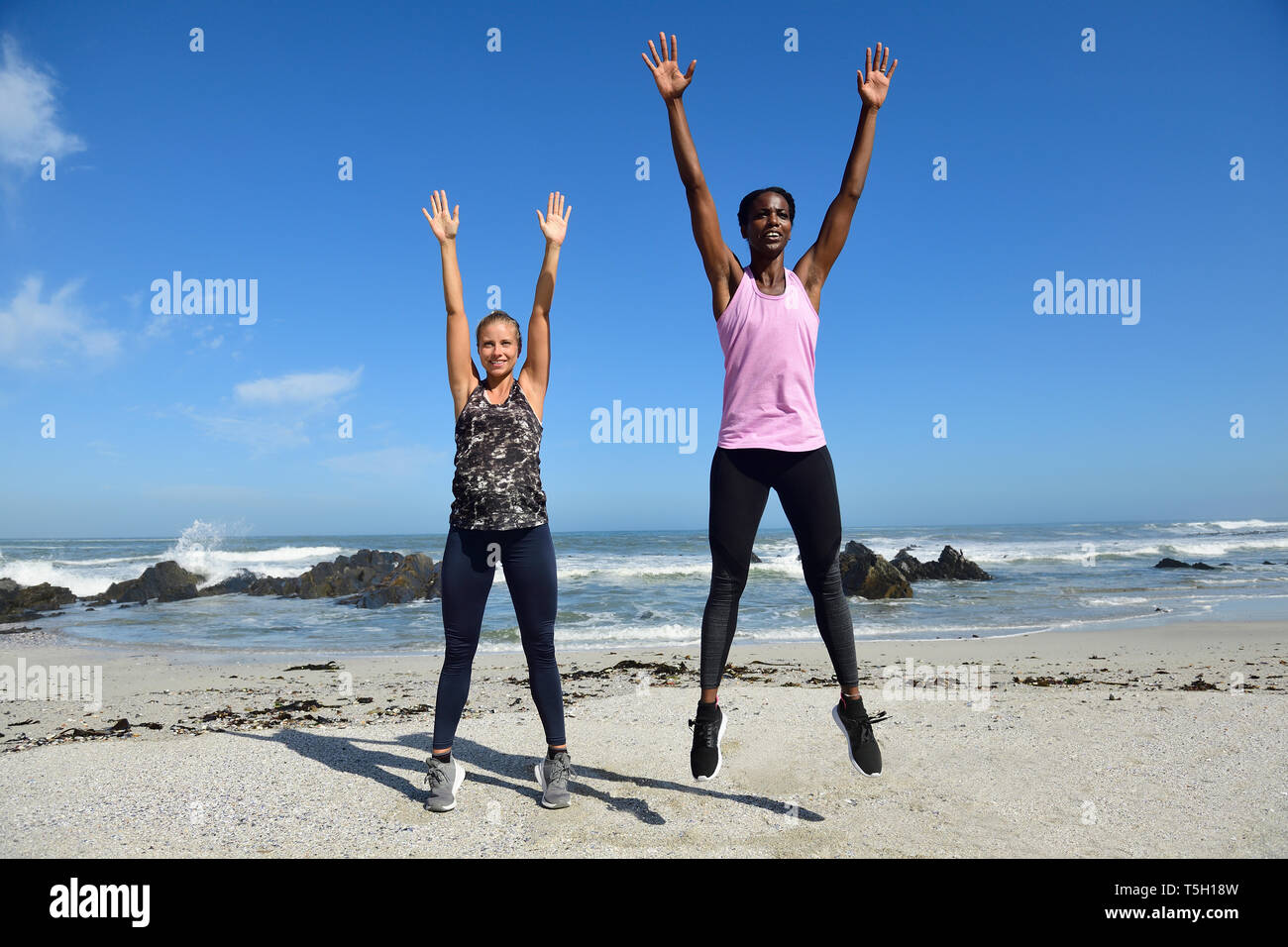 Deux femmes de faire des exercices de remise en forme sur la plage Banque D'Images