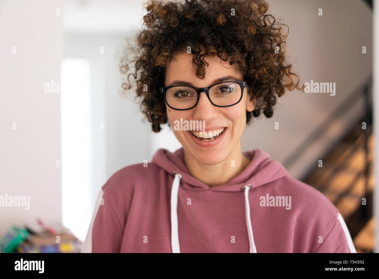 Portrait d'une jeune femme aux cheveux bouclés, portant des lunettes Banque D'Images
