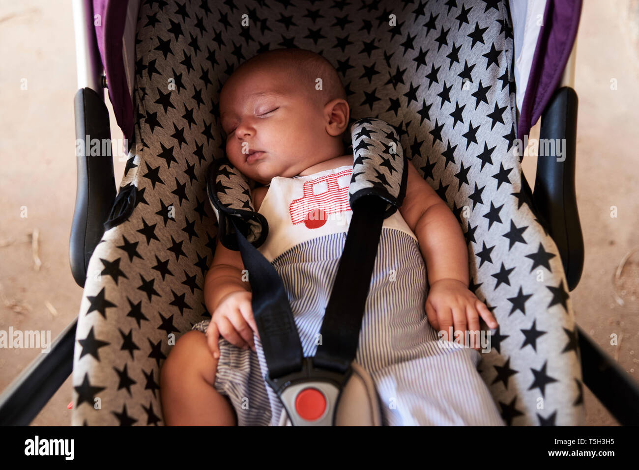 Portrait de petit garçon dormir dans siège pour enfants Banque D'Images