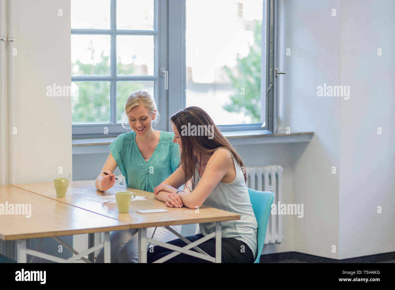 Deux smiling businessman sur le document in office Banque D'Images