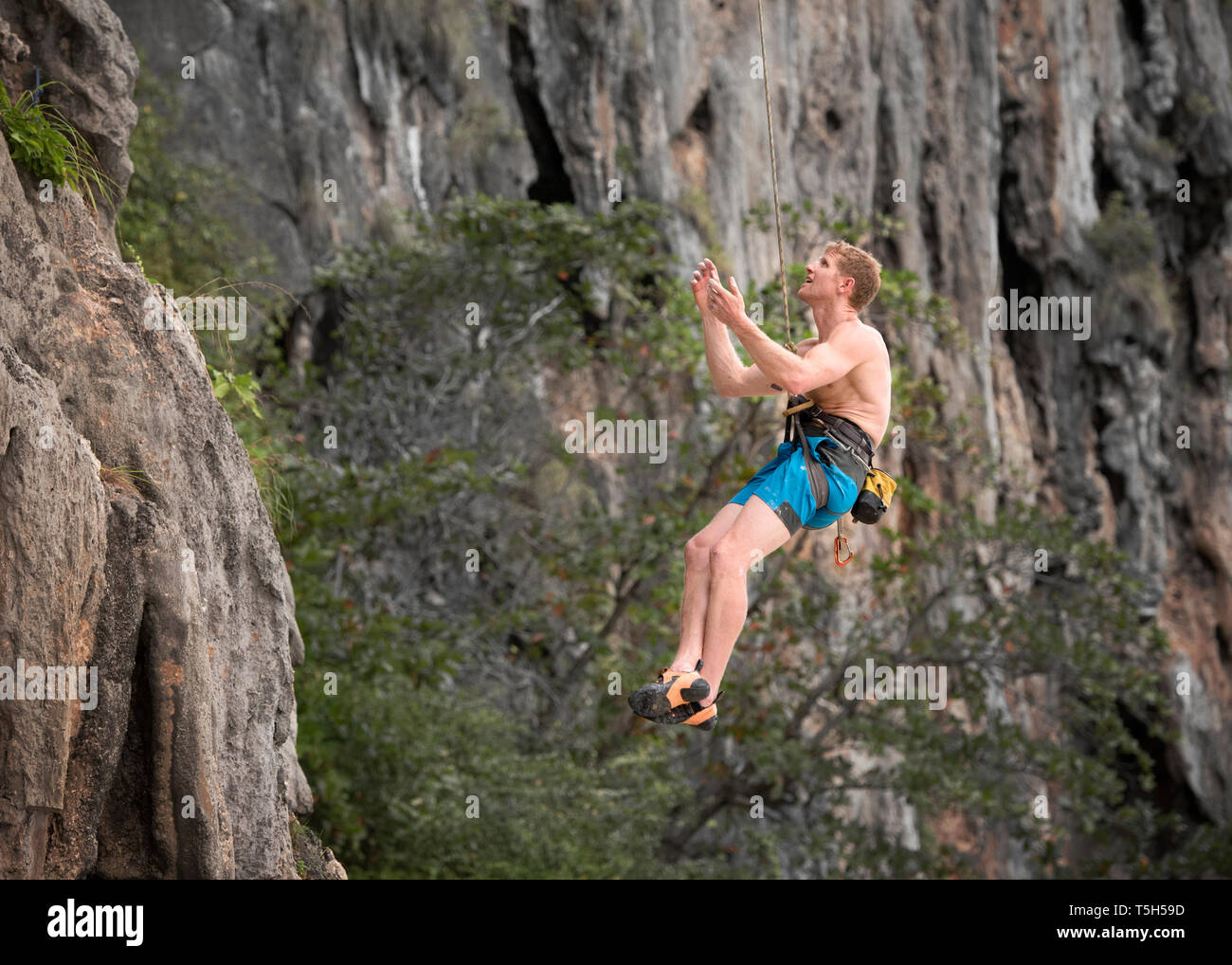 La Thaïlande, Krabi, Lao Liang, Aptenodytes forsteri climber abseiling de rock wall Banque D'Images