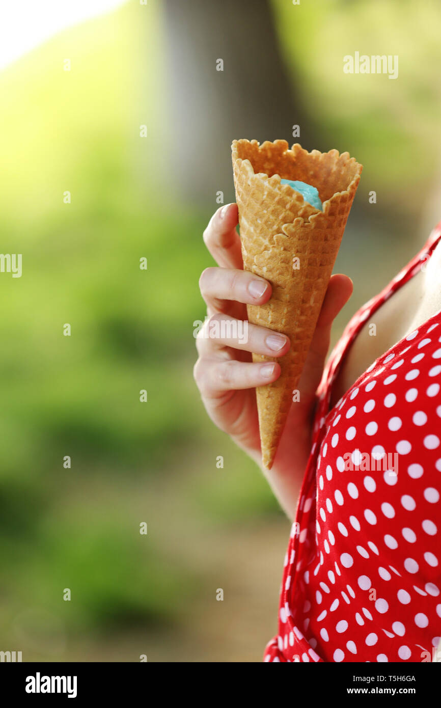 Close up image of woman holding fresh cornet gaufré à la vanille et glace à la framboise sur le fond en bois. La marche à pied. À l'extérieur Banque D'Images